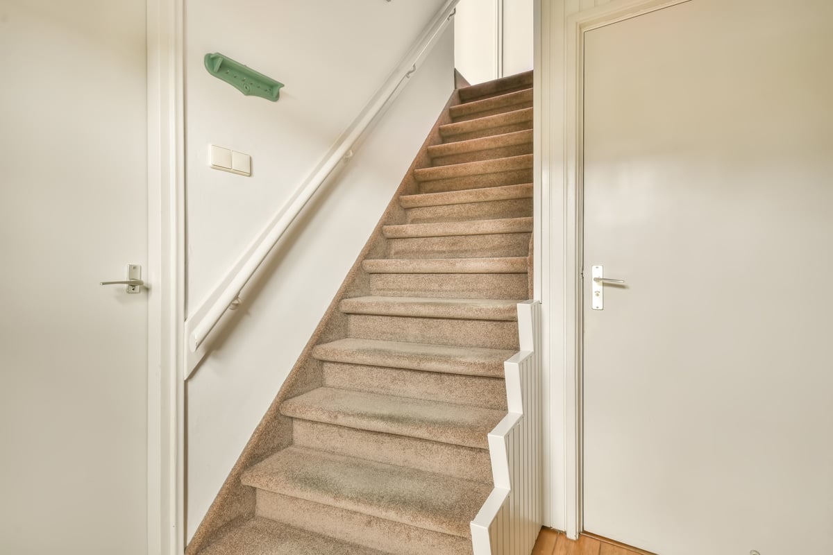 A straight light staircase with carpet steps